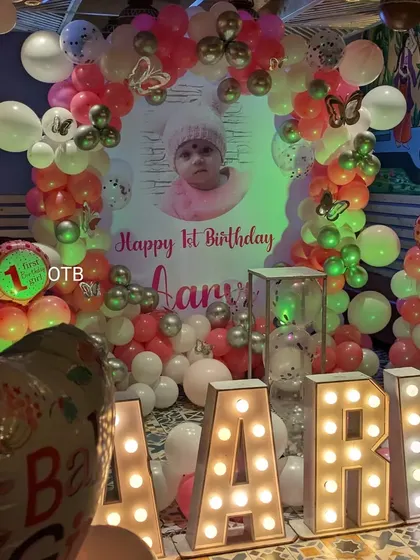 A close-up of the main backdrop for Aarvi's first birthday, featuring her name in large marquee letters.