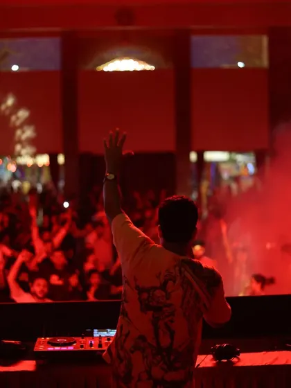 A moment of connection with the festival audience, surrounded by red lights and atmospheric smoke. Creating these big moments is a key part of my festival DJ performance.