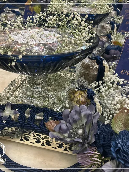 A detailed shot of the Azure Crystal Bowl Hamper, focusing on the intricate silver-plated tray, the deep blue of the crystal, and the custom floral arrangements that tie it all together.