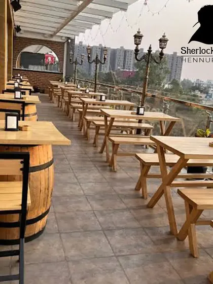 Welcome to my rooftop sports bar. I've set up long tables and benches so you and your squad can have plenty of space. It’s an open-air setup, perfect for enjoying the Bangalore weather while you watch the match.