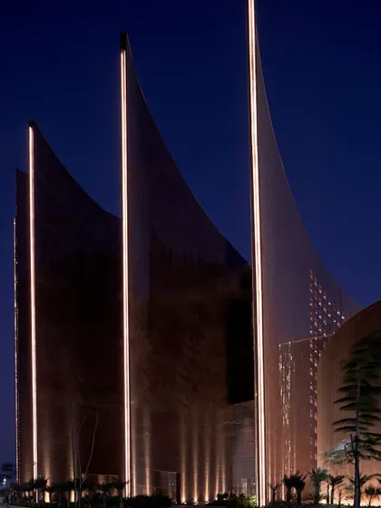 At night, the illuminated fins of the Surat Diamond Bourse highlight the building's dramatic architectural form. This lighting design emphasizes the verticality and sculptural quality of the fins, which are fundamental to the project's bioclimatic design strategy.