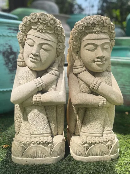Our sandstone dolls, with their intricately carved floral headdresses, look beautiful in a sunny garden. The natural stone texture catches the light, highlighting the craftsmanship.