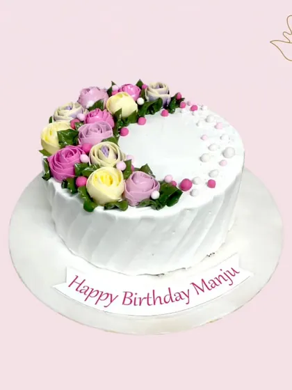 Wishing Manju a very happy birthday with this special floral cake. The buttercream roses in shades of pink, lavender, and cream create a beautiful and delicate design perfect for any celebration.