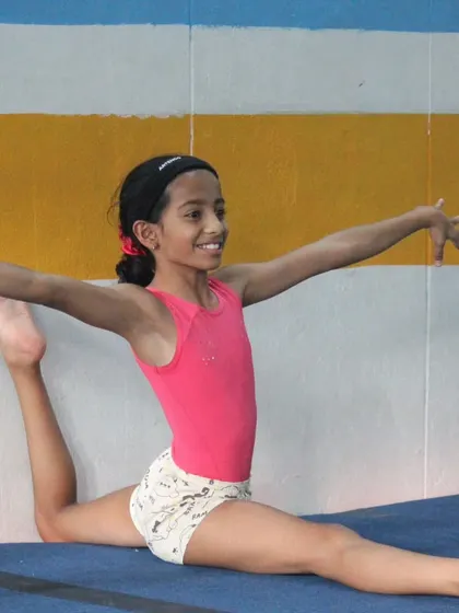 A perfect oversplit on the floor. This level of flexibility is achieved through consistent and safe stretching techniques taught by our coaches.