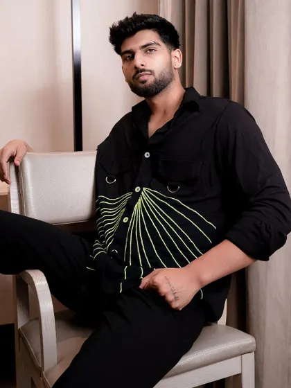 A model seated in a modern chair, wearing a shirt with a unique graphic design. This shot is great for e-commerce listings or a brand's social media.