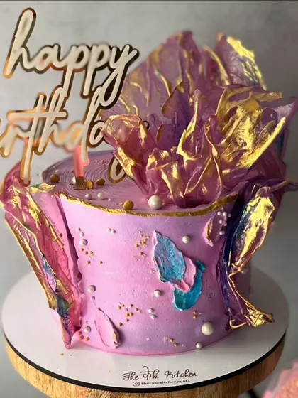 This vibrant purple cake is decorated with abstract brushstrokes of color and dramatic, gold-dusted rice paper sails for a truly artistic finish.