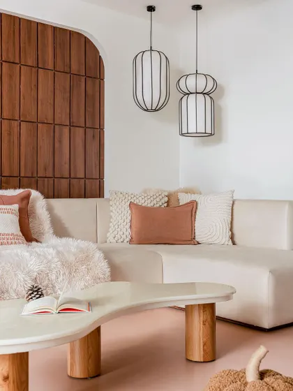 A detail of the family lounge, showing the custom-designed coffee table and sofa against a backdrop of warm wood paneling.