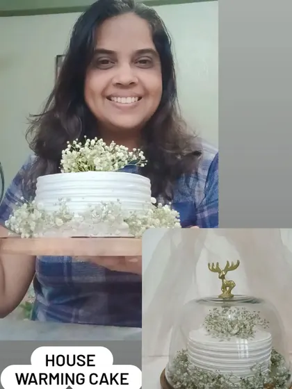 Me holding a simple and elegant housewarming cake decorated with baby's breath flowers.