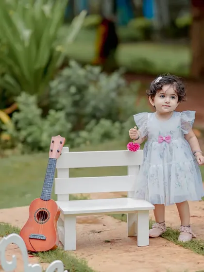 A tiny musician and her guitar. This setup with a miniature bench and instrument is perfect for a whimsical and sweet portrait of a baby girl. The natural garden setting adds to the soft, dreamy feel.