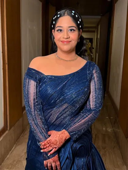 A front-facing view of this elegant party style, showing the flawless makeup and chic hair accessory.