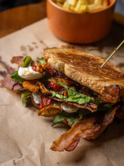 This isn't your everyday BLT. I've layered crispy bacon, fresh arugula, and sweet onion jam with a creamy aioli, all tucked inside soft milk bread. It’s a sandwich that’s both comforting and a little adventurous.