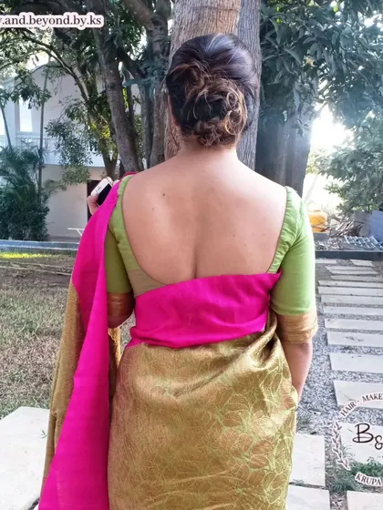 A full view of the messy updo and the client's beautiful saree. The hairstyle complements her deep-back blouse, making it a great choice for outfits that feature an interesting neckline or back design.
