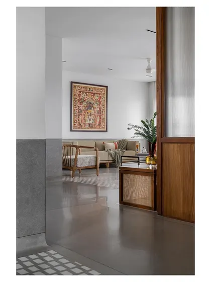 A glimpse into a living area from a hallway, where a large piece of traditional art provides a focal point.