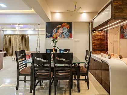 Another angle of this dining space, showing its connection to the living room with the swing in the background. The design ensures the entire area feels open and connected.