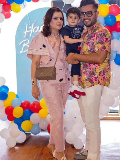 A stylish family poses for a photo at a birthday celebration.
