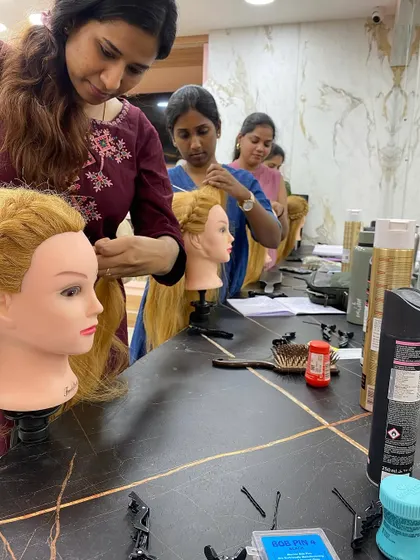 Students working together during a hairstyling practice session, learning from each other.