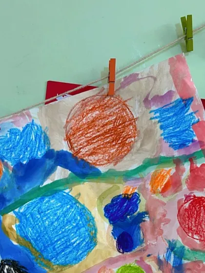 A student's artwork hanging to dry, a colorful reminder of a fun and creative online session.