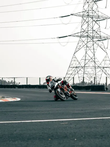 A rider on a KTM cornering at the CoASTT track.