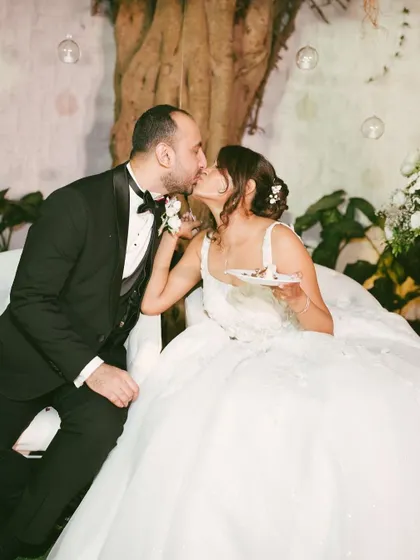 A sweet and playful moment during the cake cutting. The bride feeding the groom a piece of cake is a classic wedding moment, captured here with genuine joy.