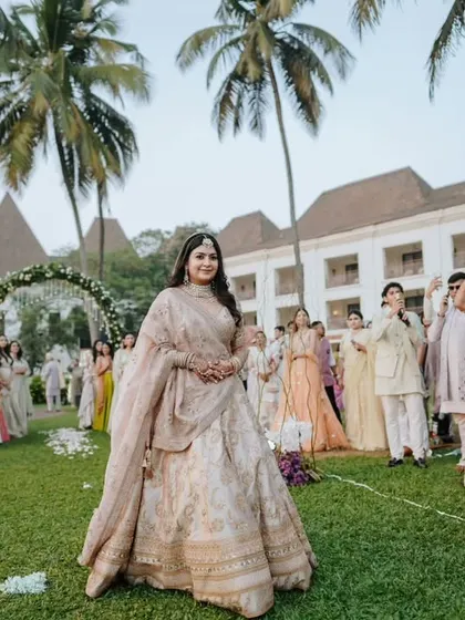 A wide shot of the bride's entrance at her outdoor Goa wedding, capturing the full scene with guests and the beautiful venue.