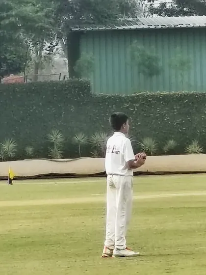 A young fielder in position during a KSCA U-12 league match, showcasing focus and readiness.