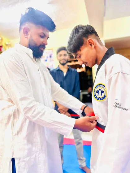 Tying the red and black belt, a symbol of high skill and dedication.