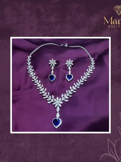 A classic design with a touch of drama. This diamond necklace features a leaf-like pattern leading down to a stunning heart-shaped sapphire. It's the perfect piece for someone who loves timeless elegance with a pop of color.