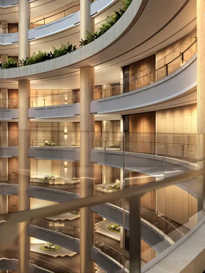 The multi-level atrium of Palais Royale, showcasing the grand scale and structural ingenuity of the design. The curved balconies and supporting columns create a powerful rhythm, emphasizing the building's verticality.