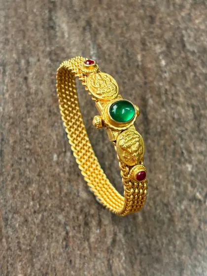 What’s better than a silver product that looks exactly like gold? This is my 925 sterling silver kada with a thick gold plating, featuring temple coin motifs and a central green stone.