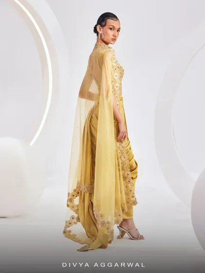 The back view of the LYDIA Cape Set, showcasing the dramatic, floor-length organza cape with 3D floral embroidery.