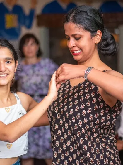 Two friends dancing together and smiling. The community aspect is so important to us.