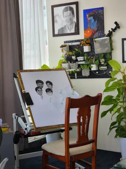 My studio setup for the large A1 size family portrait. You can see the initial faces taking shape on my drawing board, with the reference photos close by for constant comparison.