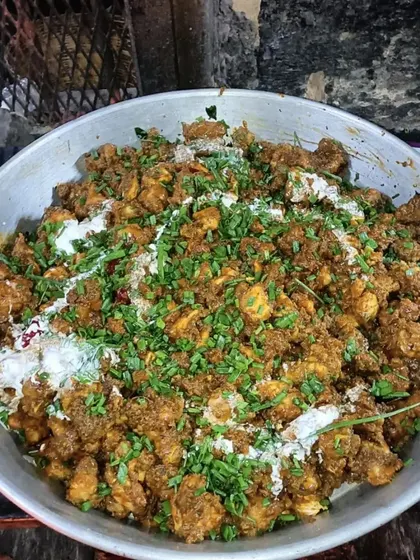 A close-up of one of our popular chicken starters, full of masala and garnished with fresh herbs.