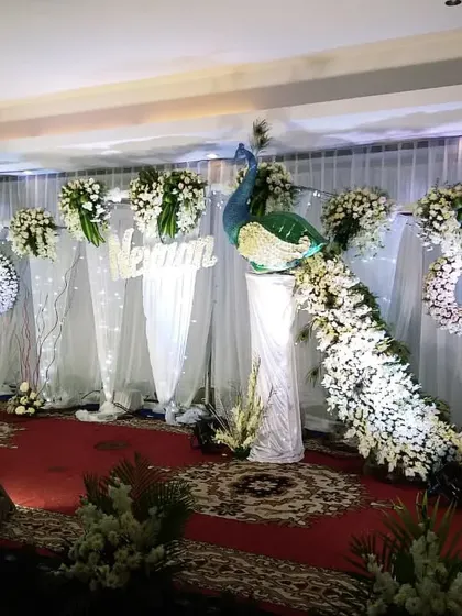 Another view of the white peacock-themed naming ceremony. The white drapes and fairy lights in the background add a soft, dreamy feel to the entire setup.