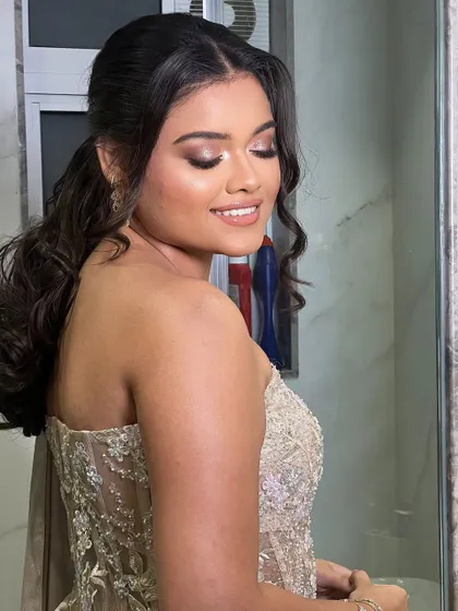 The combination of a sleek top and curly ponytail creates a sophisticated and trendy look for the sister of the bride.