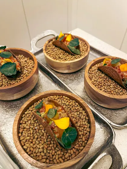 Canapé-sized mushroom tacos presented in individual bowls. These feature a fermented garlic aioli, green papaya som tam, and a truffle egg yolk gel.