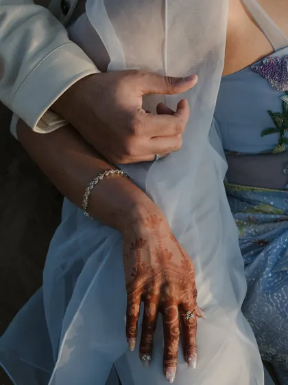 A close-up on the embrace, focusing on the hands and the intricate details of the outfits. It’s a subtle way to show connection and artistry.