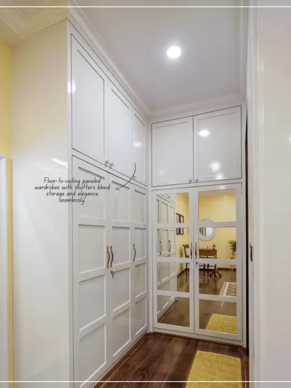 A view of the corridor from the bedroom in image 24, showing the floor-to-ceiling white paneled wardrobes.
