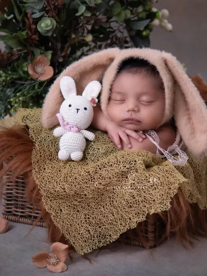 A close-up of our bunny theme, showing the baby's peaceful expression and the soft, fuzzy textures of the bonnet and basket.