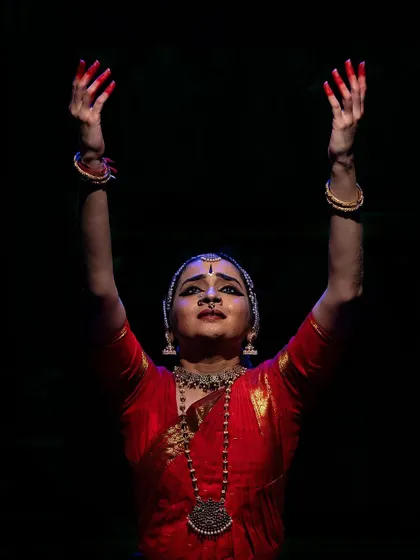 A moment of devotion with hands raised in offering. The upward gaze and serene expression are directed towards the divine presence.