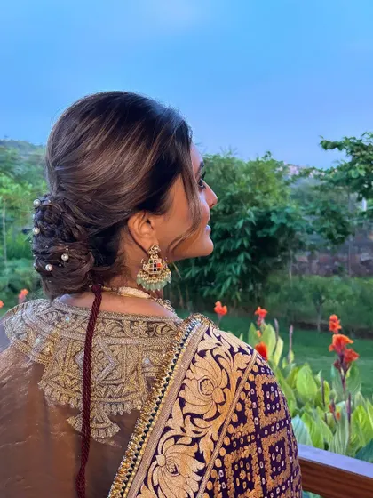 This shot captures the beautiful texture and detail of the low bun against a natural backdrop. It’s a perfect hairstyle for an outdoor or destination wedding.