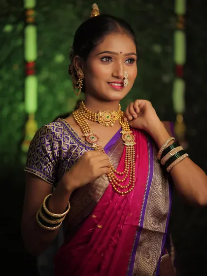 Adjusting the layered necklaces is part of perfecting the traditional bridal look. Every piece of jewelry is placed carefully to enhance the overall appearance.
