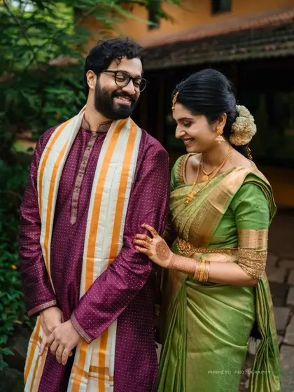 A sweet, candid moment between the couple, sharing a smile in a lush, green setting at the Shankara Foundation.