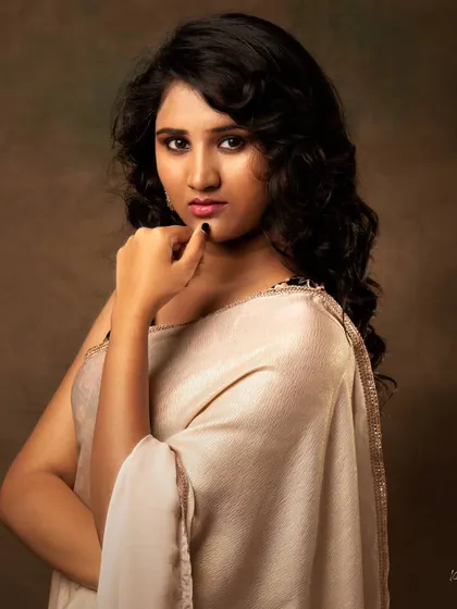 A similar pose from the same studio session, capturing a slightly different, more thoughtful expression.