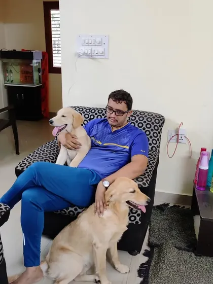 Shreyas relaxing with a sleepy puppy on his lap and our own dog nearby. This is how we spend most of our evenings, surrounded by our furry kids.