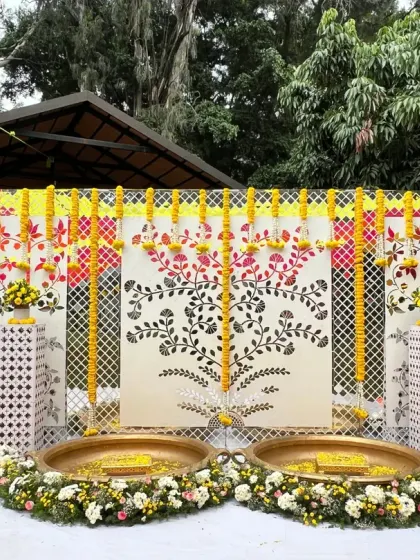 A full view of our modern mirror Haldi decor, combining traditional marigold garlands with elegant white panels and floral arrangements.