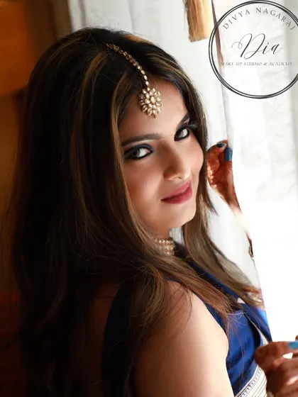 A classy and glamorous look for a cocktail party or reception. This style features a bold, smokey eye and a deep red lip, creating a dramatic and confident appearance. The side-swept hair adds a touch of Hollywood glamour.