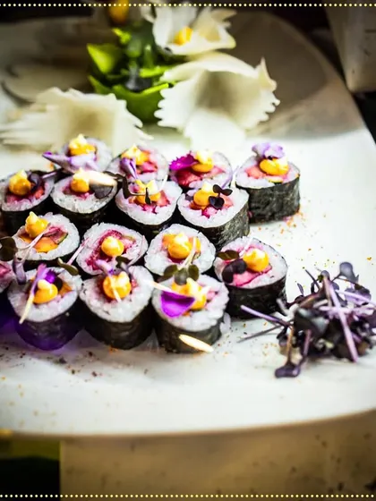 Beautifully crafted sushi rolls adorned with edible flowers and microgreens, showcasing our expertise in Asian cuisine for a lavish wedding.