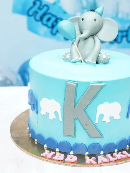 A close-up of the custom-designed cake for the elephant-themed birthday, featuring a fondant elephant topper and matching color scheme.