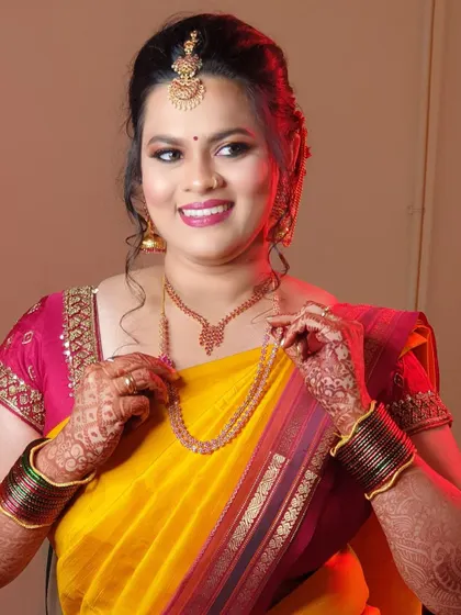 A lovely portrait of Archana for her Varapooje. Her makeup features a bright, warm-toned lipstick that beautifully complements her yellow and pink saree.